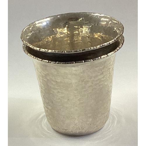 322 - A pair of Continental silver stacking shot cups with hammered decoration. Approx. 52 grams. Est. £40... 