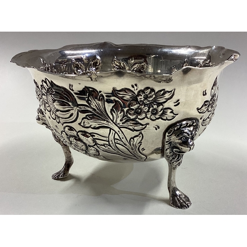 417 - DUBLIN: A clean Irish silver bowl with embossed decoration and lion mask feet. 1929. By West & Son. ... 