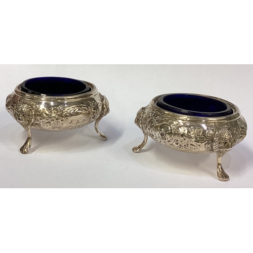 502 - A heavy pair of chased silver salts. Birmingham. By GU. Approx. 94 grams. Est. £50 - £80.