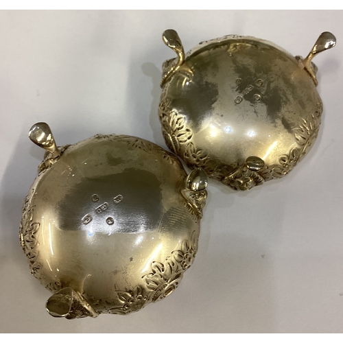 502 - A heavy pair of chased silver salts. Birmingham. By GU. Approx. 94 grams. Est. £50 - £80.