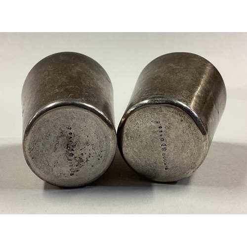 533 - A pair of Continental silver stacking beakers. Marked to bases. Approx. 42 grams. Est. £40 - £60.