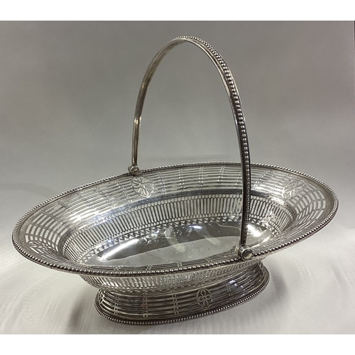 562 - A large and impressive 18th Century silver swing handled basket with crested decoration. London 1789... 