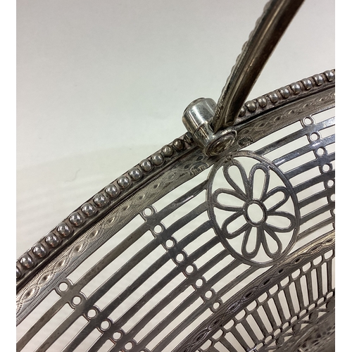 562 - A large and impressive 18th Century silver swing handled basket with crested decoration. London 1789... 