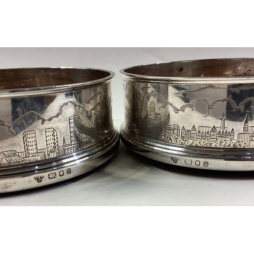 586 - A rare pair of silver wine coasters decorated with engraved scenes of London. 1989. By CJ Vander. Ap... 