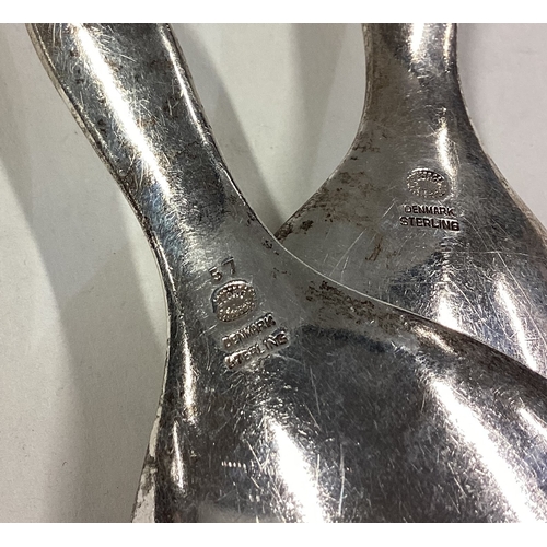 589 - GEORG JENSEN: A pair of silver serving spoons. Approx. 160 grams. Est. £300 - £400.