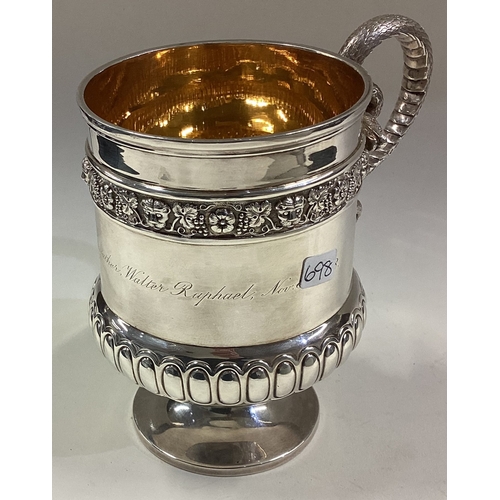 698 - An attractive Victorian silver half fluted mug on circular pedestal foot and entwined snake handle. ... 