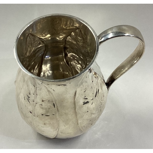 71 - A heavy silver christening mug embossed with four plaques of leaves. Sheffield 1954. Approx. 177 gra... 