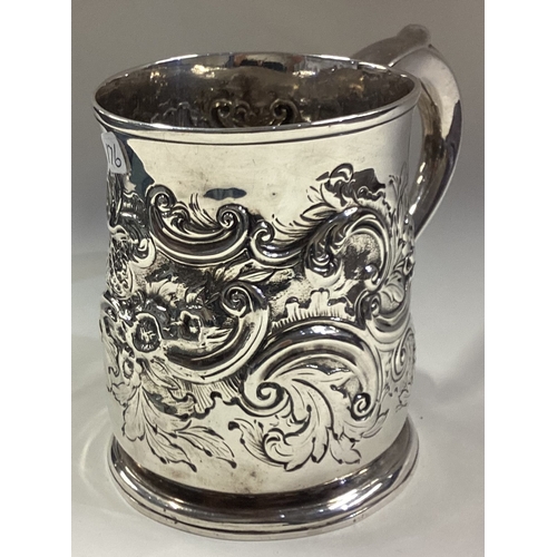 176 - A large chased Georgian silver mug. London. By IE. Approx. 313 grams. Est. £200 - £300.