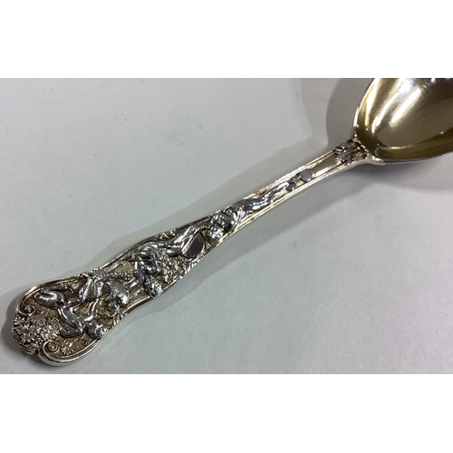 597 - A heavy cast silver gilt preserve spoon decorated with flowers and leaves. London. Approx. 72 grams.... 