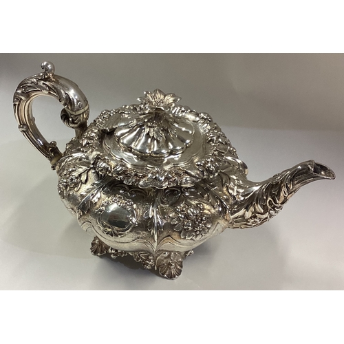 686 - An attractive bachelor's late Victorian silver teapot decorated with scrolls, flowers and leaves. Lo... 