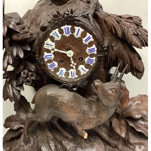 186 - A Continental carved oak mantle clock. Est. £40 - £60.