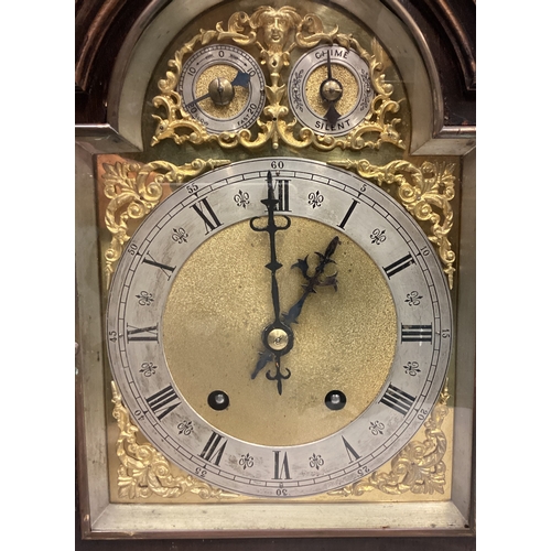 198 - An oak bracket clock on brass supports. Est. £50 - £80.