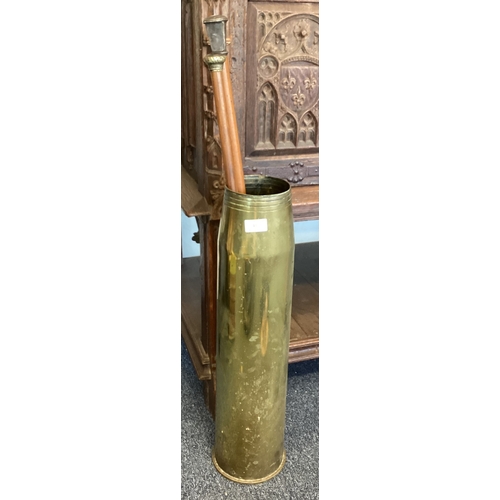 417 - A large brass shell case containing silver mounted walking sticks. Est. £20 - £30.