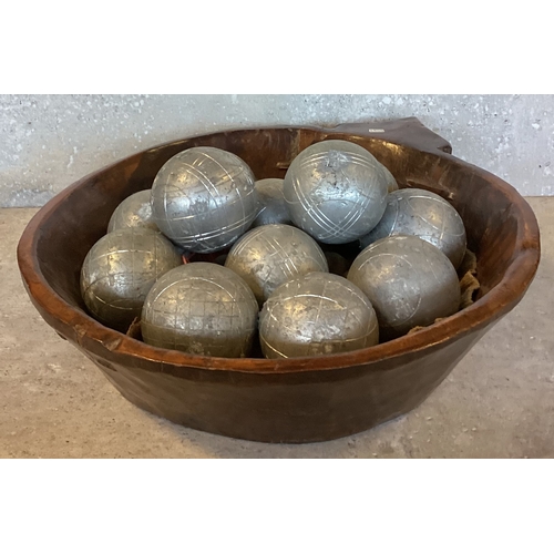 479 - An unusual carved wooden bowl. Approx. 37 cms diameter. Together with a full set of steel Pétanque b... 