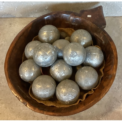 479 - An unusual carved wooden bowl. Approx. 37 cms diameter. Together with a full set of steel Pétanque b... 