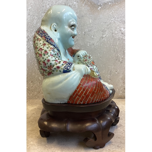 403 - A Chinese figure of a Buddha in seated position on carved stand. Marked to base. Est. £200 - £300.