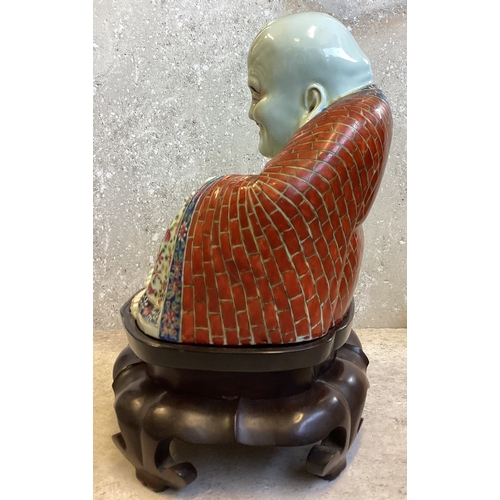 403 - A Chinese figure of a Buddha in seated position on carved stand. Marked to base. Est. £200 - £300.