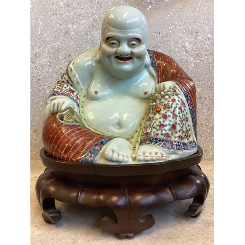 403 - A Chinese figure of a Buddha in seated position on carved stand. Marked to base. Est. £200 - £300.