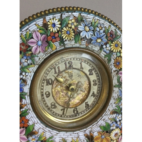 497A - A micro mosaic desk clock with floral decoration and winged infant to dial. Pen marked 'Boscowan E/R... 