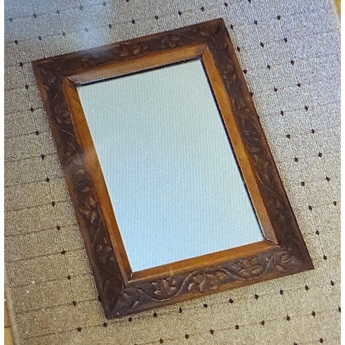 495 - A small oak carved mirror. Est. £30 - £50.