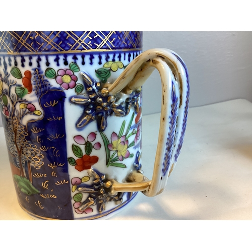 475A - A large Oriental style china tankard with decorative entwined handle. Inscribed to base. Approx. 13.... 