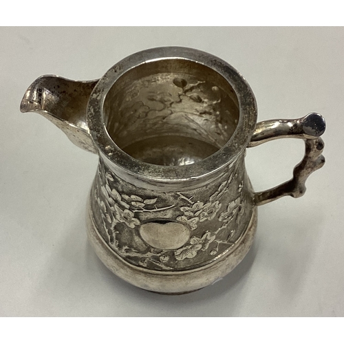 118 - A 19th Century Chinese export silver jug with embossed decoration. Approx. 152 grams. Est. £150 - £2... 