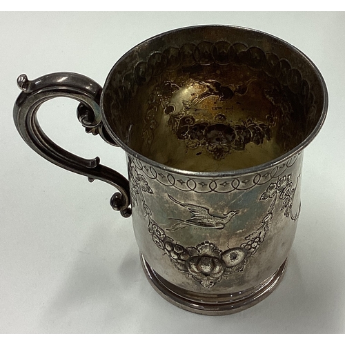 14 - A chased Victorian silver mug with embossed floral and bird decoration. By Barnards. Approx. 111 gra... 