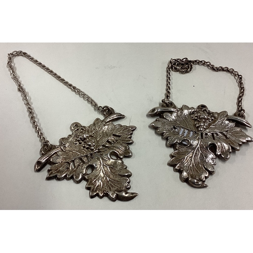 220 - A pair of Victorian silver wine labels for 'Madeira' and 'Sherry' with grape and vine decoration. Ap... 