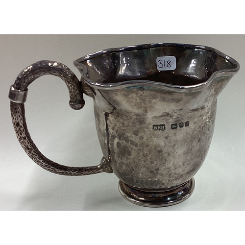 318 - A novelty Modernistic silver mug of unusual form with hammered handle. London 1975. By WRH. Approx. ... 