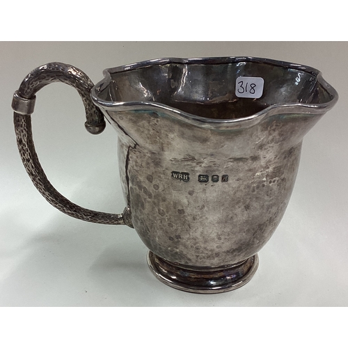 318 - A novelty Modernistic silver mug of unusual form with hammered handle. London 1975. By WRH. Approx. ... 