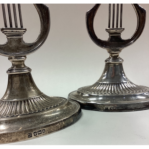 335 - A rare pair of silver candlesticks with lyre decoration. Sheffield 1912. By Fordham & Faulkner. Appr... 