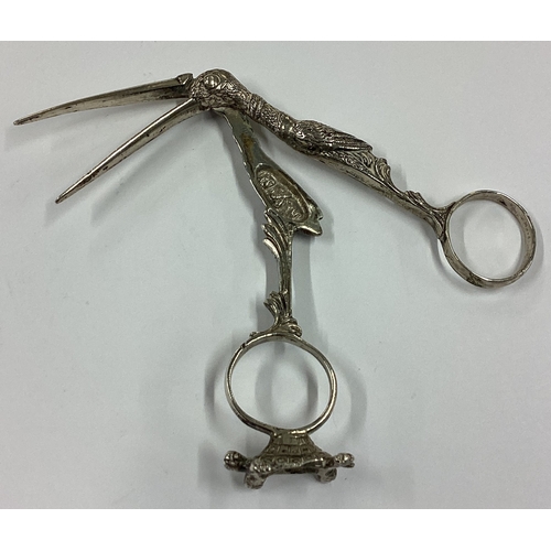 337 - A novelty pair of silver ice tongs in the form of a stork with concealed baby inside standing on a t... 