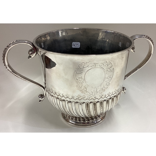 405 - A large Queen Anne silver porringer of fluted design with beaded decoration to handle. London 1713. ... 