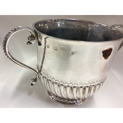 405 - A large Queen Anne silver porringer of fluted design with beaded decoration to handle. London 1713. ... 