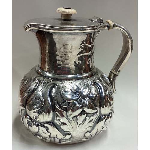 411 - A fine and rare 19th Century American silver wine jug with embossed and chased floral decoration and... 