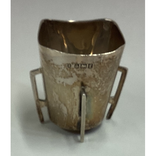 429 - A silver tyg cup on four feet. London 1901. Approx. 31 grams. Est. £30 - £40.