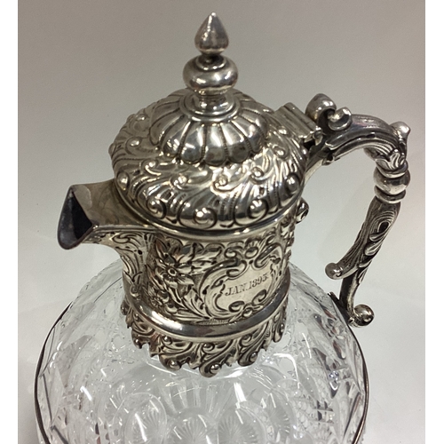 438 - A Victorian silver claret jug with embossed decoration. London 1890. By CE/JL. Est. £300 - £400.