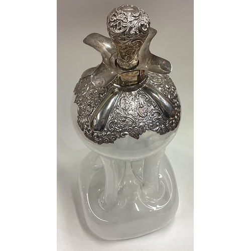 439 - A large silver mounted and glass decanter with lift-off cover chased with floral decoration. Birming... 