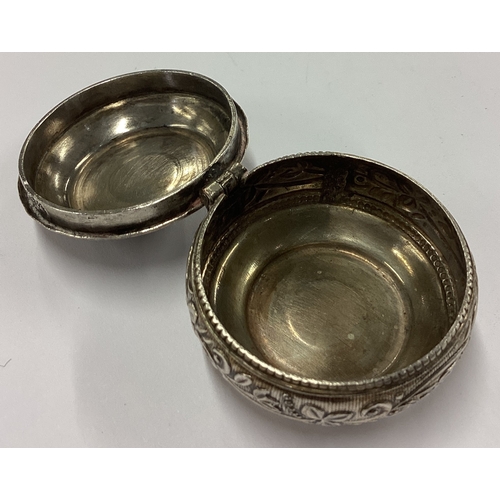 46 - A silver hinged pill box with chased grape and vine decoration. Approx. 23 grams. Est. £30 - £40.