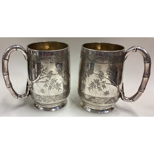 597 - CUMSHING: A large and oversized pair of 19th Century Chinese export silver tankards with engraved dr... 