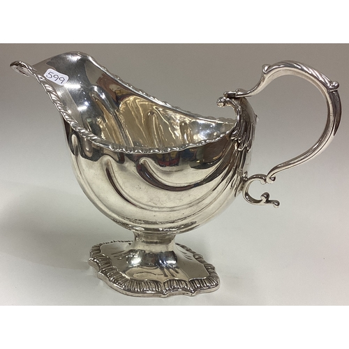 599 - A good 18th Century silver sauce boat with rare fluted decoration and central armorial. London 1766.... 