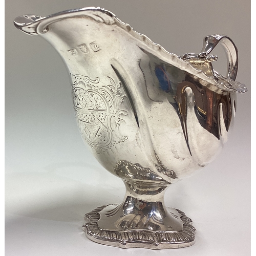 599 - A good 18th Century silver sauce boat with rare fluted decoration and central armorial. London 1766.... 