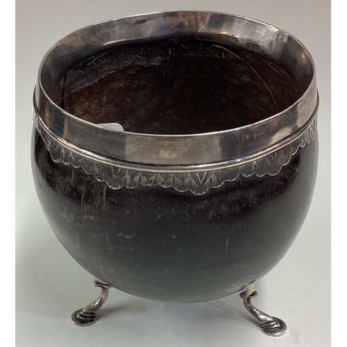 605 - An 18th Century Provincial silver mounted coconut cup on feet. Circa 1720. Approx. 200 grams of gros... 