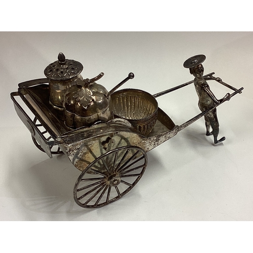 658 - A large figural Chinese silver condiment set in the form of an Oriental figure with rickshaw. By WO.... 