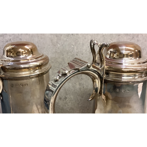 749 - A pair of George II silver flagons each of plain cylindrical form, with domed hinged lid, pierced an... 