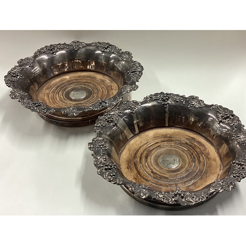 92 - A pair of Victorian silver mounted wine coasters with grape and vine decoration. Approx. 740 grams o... 