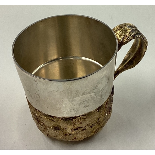 156 - STUART DEVLIN: A novelty silver mug with silver gilt decoration to body and handle. London 1982. App... 