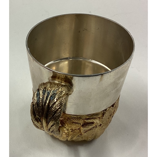 156 - STUART DEVLIN: A novelty silver mug with silver gilt decoration to body and handle. London 1982. App... 