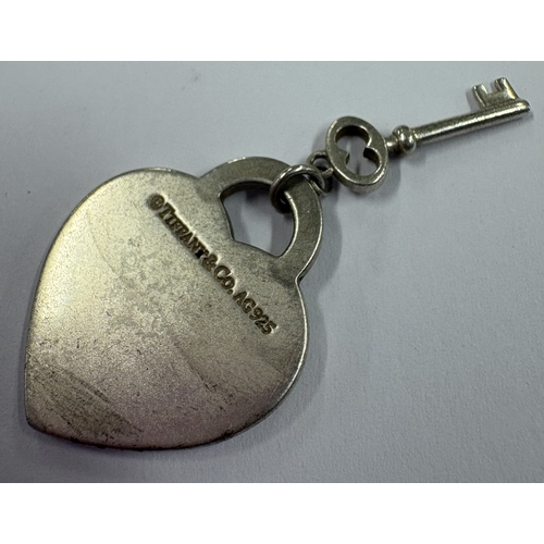 210 - A 'Please return to Tiffany' heart charm with key. By Tiffany & Co. Approx. 5 grams. Est. £10 - £20.