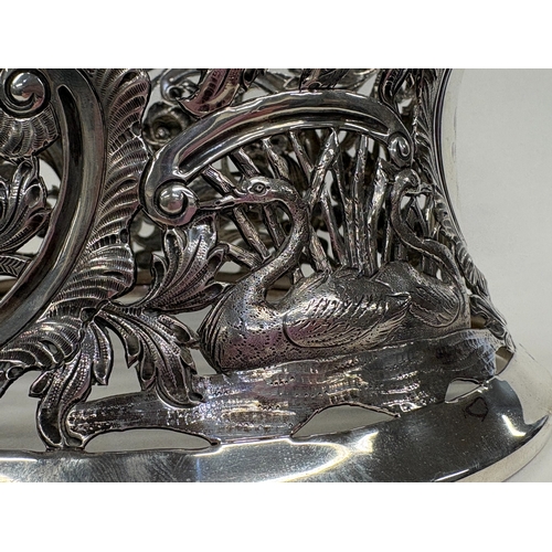 410 - DUBLIN: An Irish silver dish ring pierced with swans, cows and Chinoiserie decoration. 1915. By Wake... 